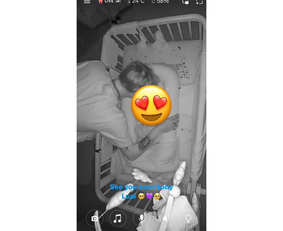 lindsay lohans baby in a crib being viewed by the nestig baby monitor