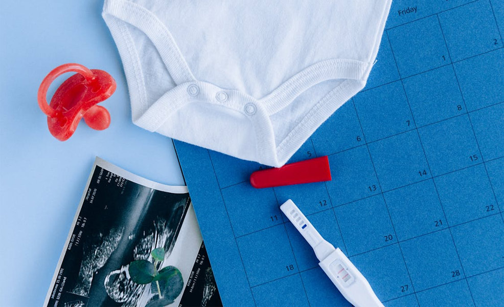 calendar with pregnancy test and pacifier and due dates