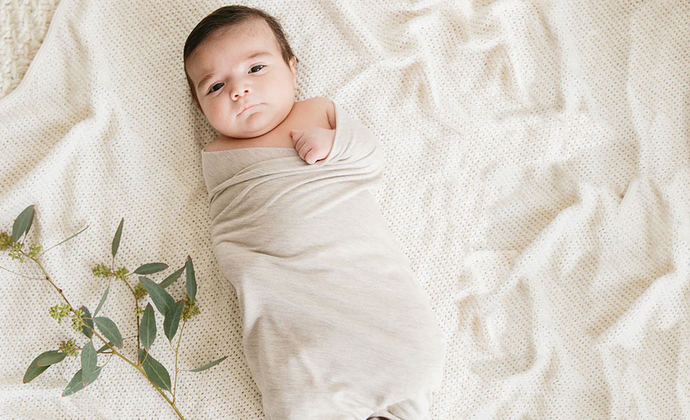a baby relaxing in a solly swaddle