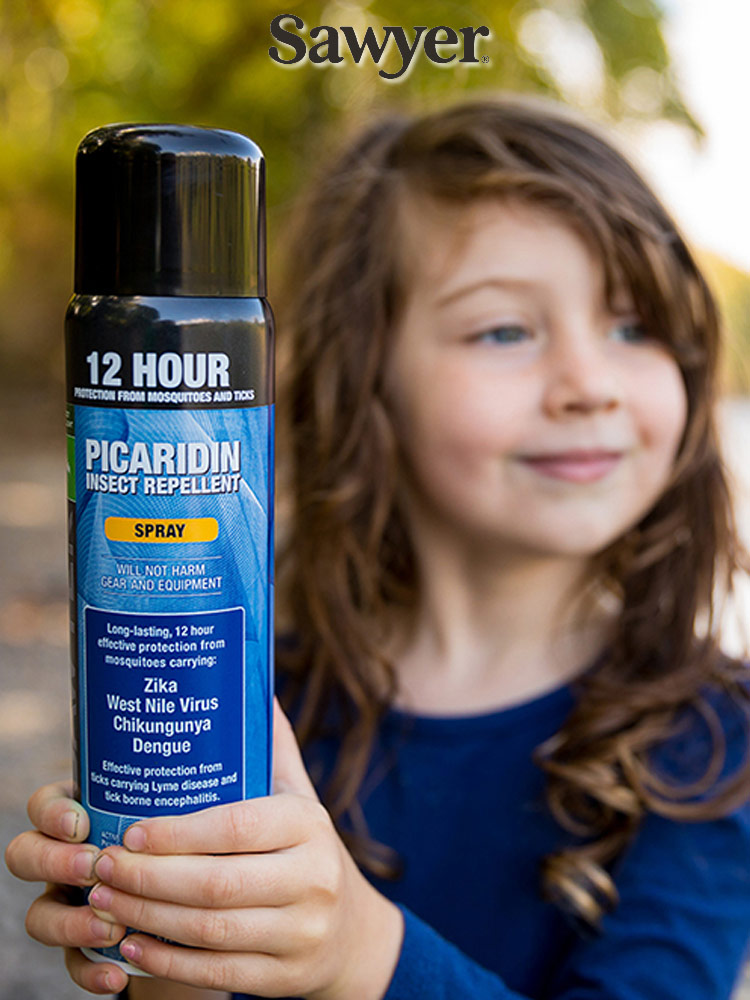 Sawyer Premium Mosquito Repellent Pump and Spray a girl in the woods holding a bottle of sawyer premium bug spray